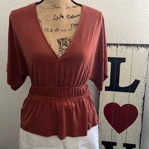 Rust colored top with detailed waist.